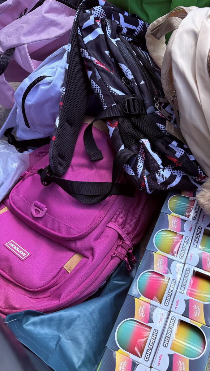 New backpacks in bright colours, stacked and ready to hand out