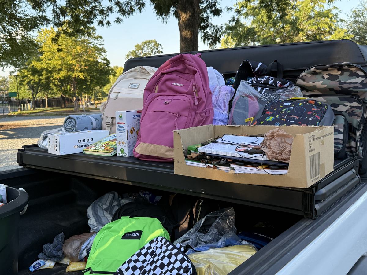 Supplies for children laid out on a tailgate before a distribution